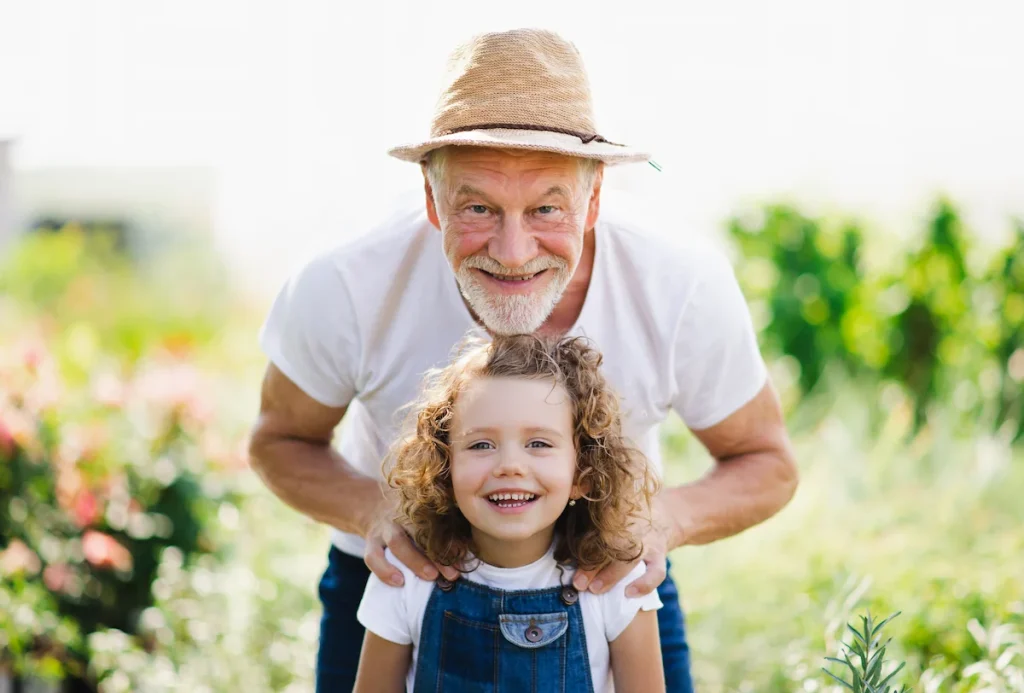 happy senior man in the garden with granddaughter