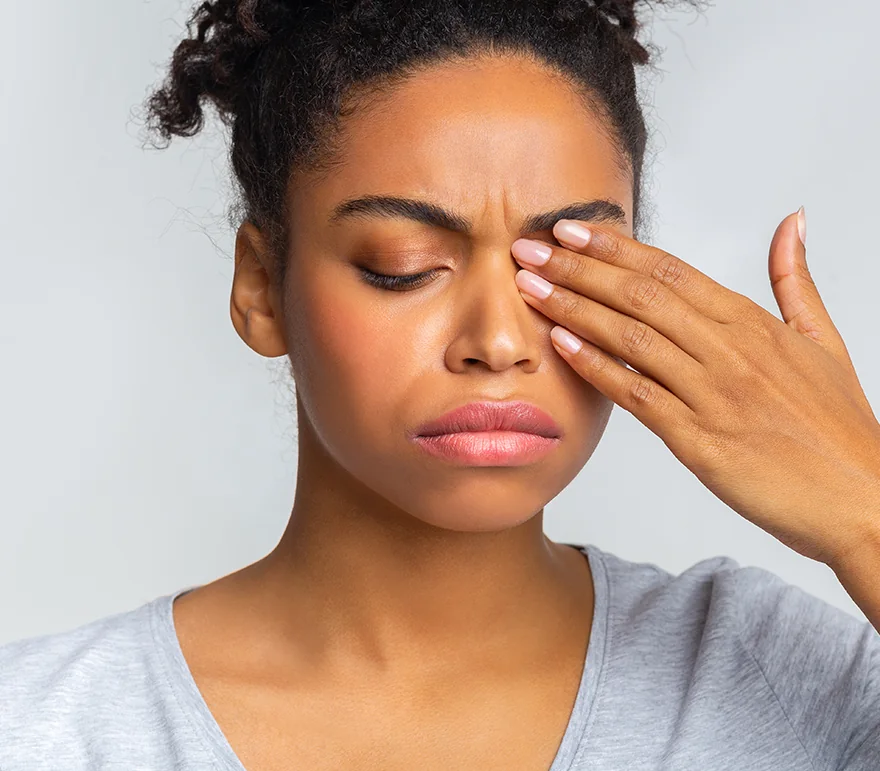 young woman with eye infection touching her eye