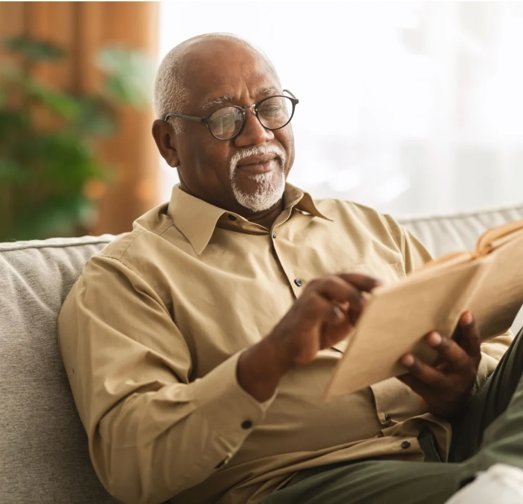 senior man reading a book at home