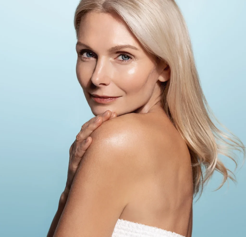 confident mature woman with glowing skin looking over shoulder