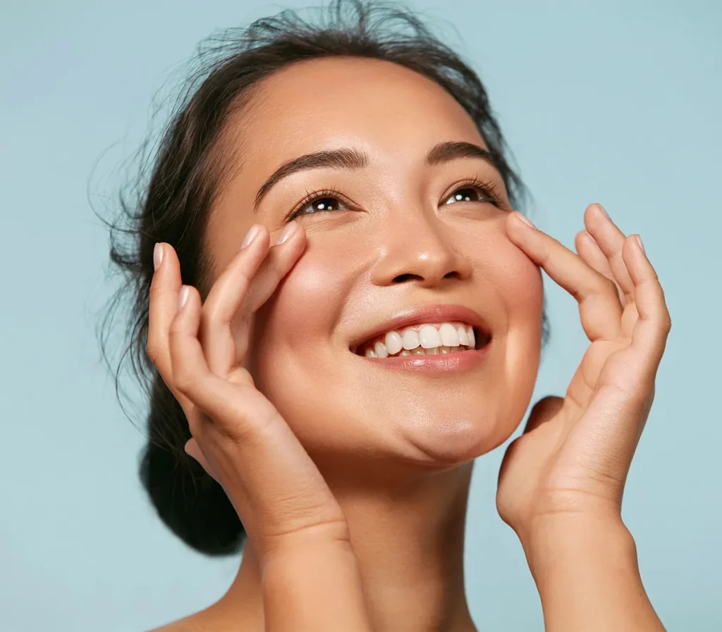 beautiful asian woman touching under eyes smiling